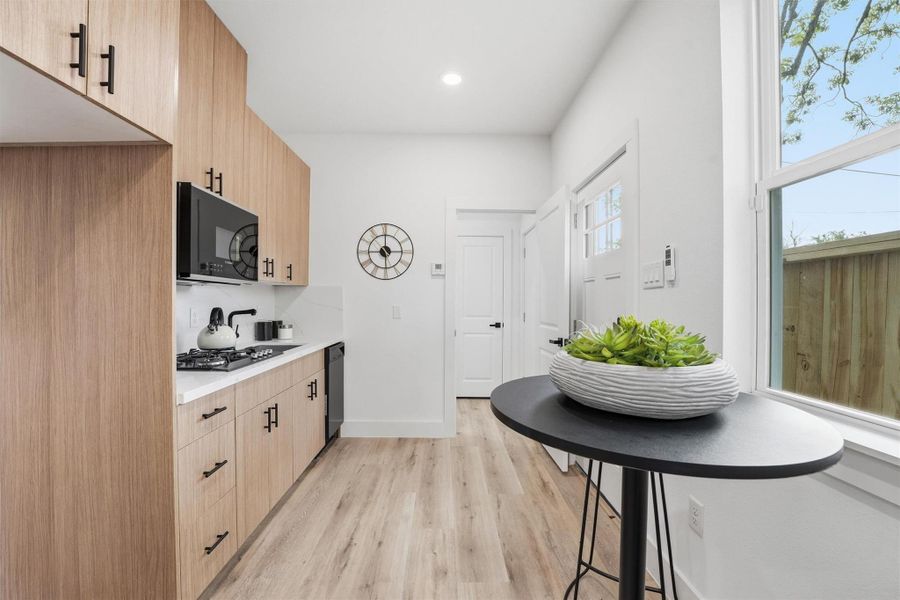 Full kitchenette in studio apartment complete with cooktop, microwave, dishwasher, and room for a refrigerator.  Everything that could be needed to live in this space either full or part time!