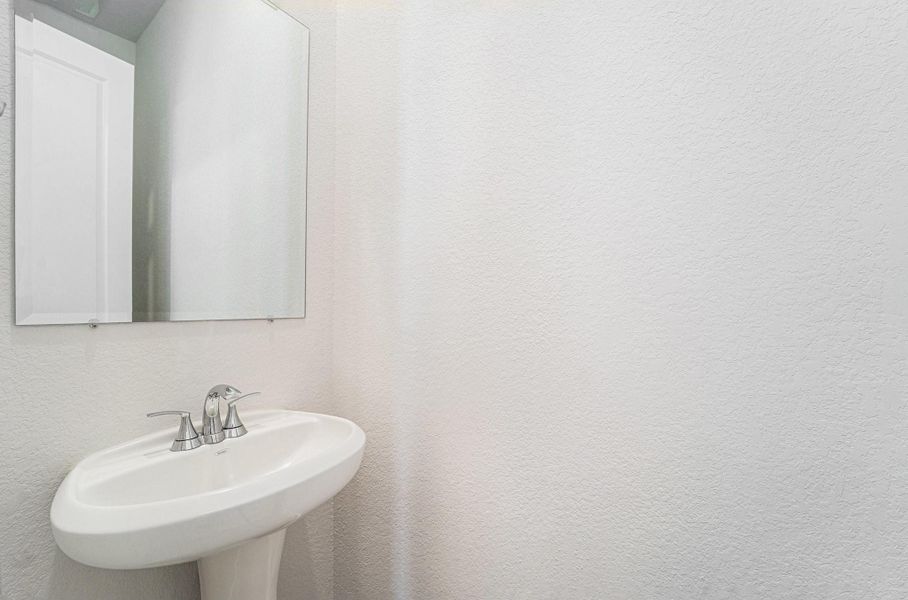 Convenient downstairs powder bath with pedestal sink.