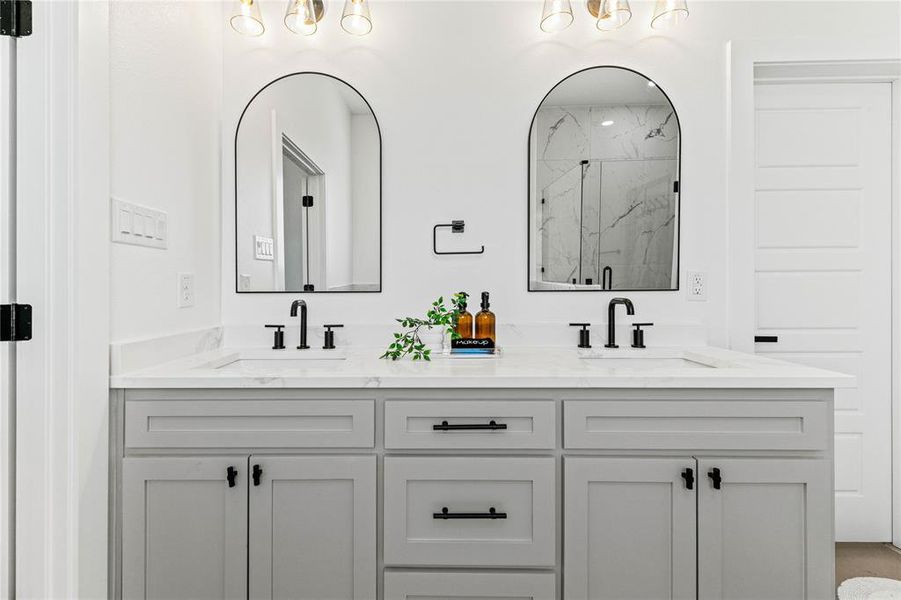Full bathroom featuring a marble finish shower and double vanity Full bathroom featuring a marble finish shower and double vanity