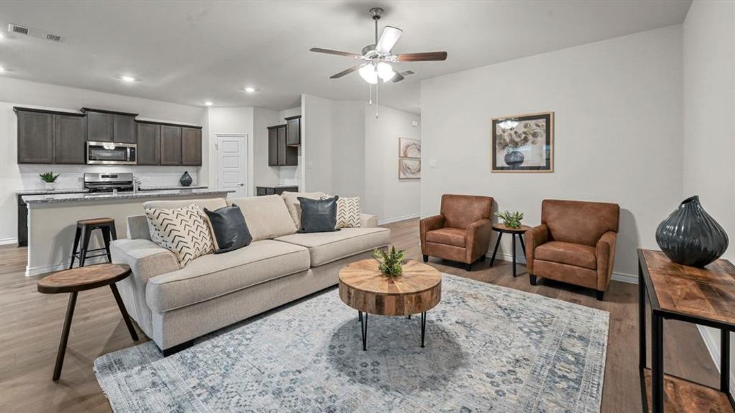 Open-concept living space featuring wood-finish flooring, a ceiling fan, and recessed lighting