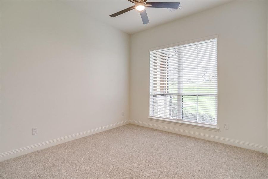Secondary bedroom with ceiling fan and walk in closet