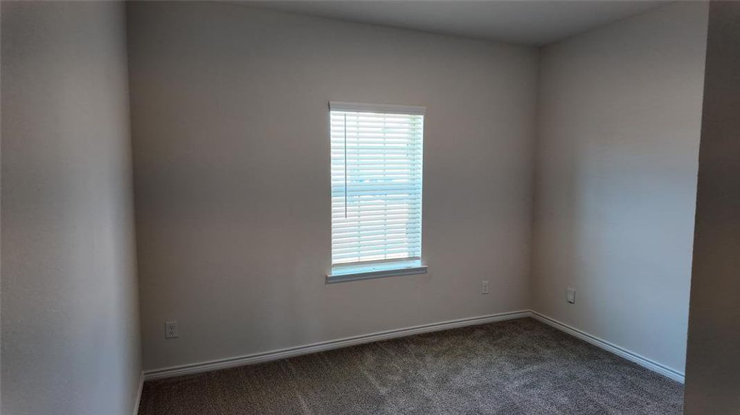 Empty room with plenty of natural light and dark carpet