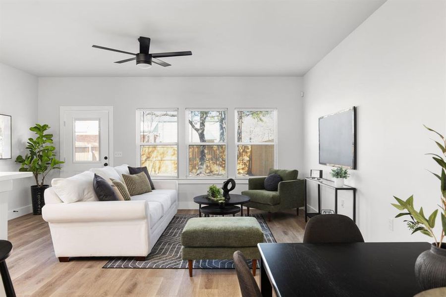 Living room featuring a ceiling fan and light wood-style flooring