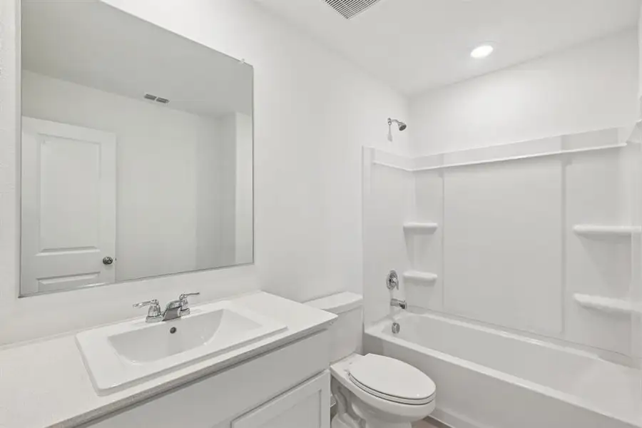 Bathroom featuring vanity and washtub / shower combination