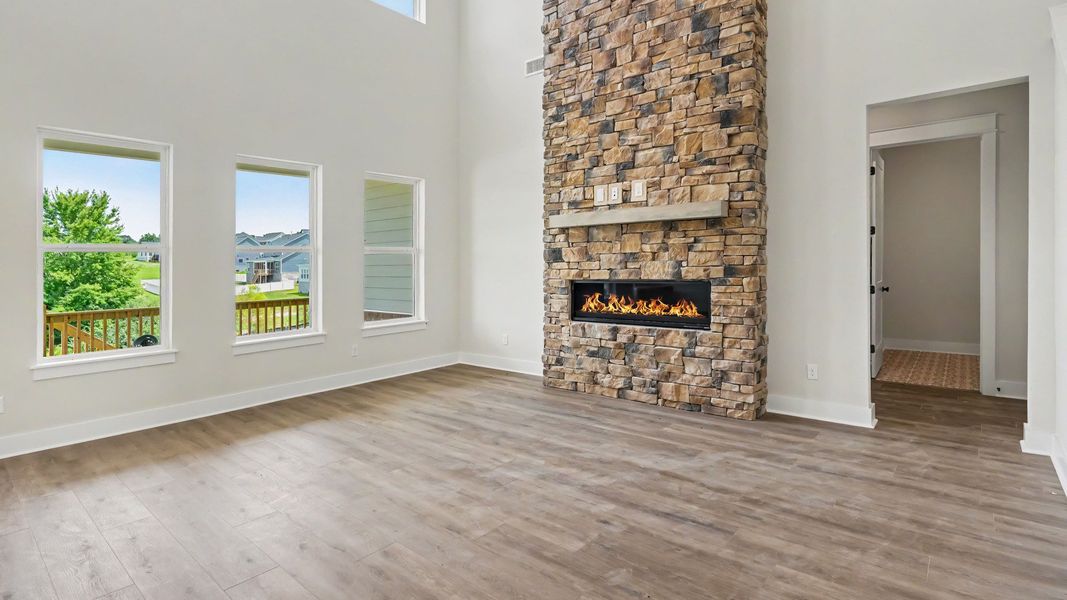 Gathering room with high ceilings, bright natural lighting from windows, and view of kitchen Gathering room with high ceilings, bright natural lighting from windows, and view of kitchen