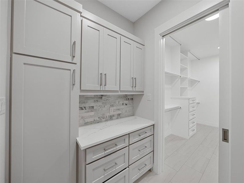 Walk in closet with light tile patterned floors