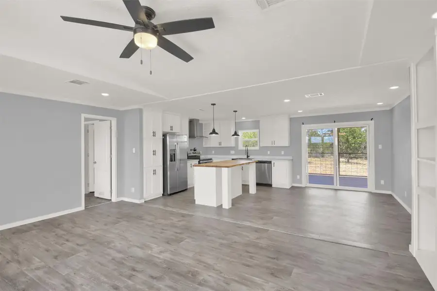 An open floorplan seamlessly connects the airy living space to a modern kitchen.