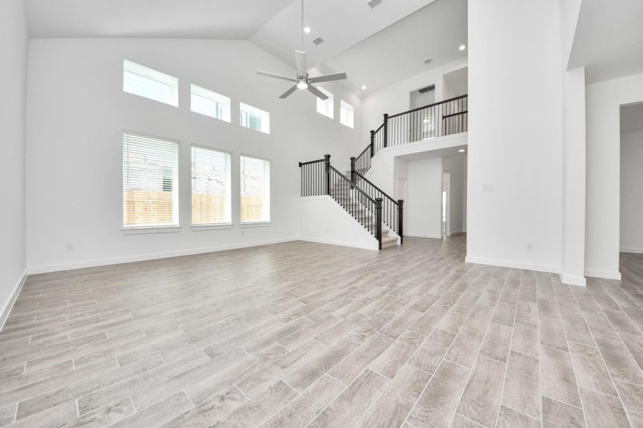 Family room flooded with natural light through the expansive windows. The premium tile flooring adds a touch of luxury to the space, creating the perfect setting for relaxing moments and cherished gatherings with loved ones. Sample photo of completed home with similar floor plan. Actual colors and selections may vary. Family room flooded with natural light through the expansive windows. The premium tile flooring adds a touch of luxury to the space, creating the perfect setting for relaxing moments and cherished gatherings with loved ones. Sample photo of completed home with similar floor plan. Actual colors and selections may vary.