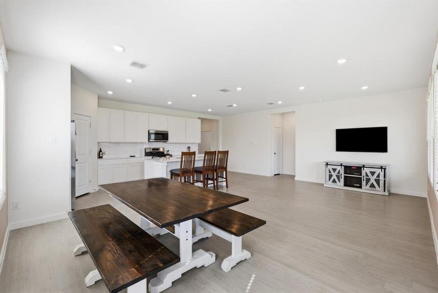 Open-concept living space featuring light wood-finish flooring, recessed lighting, and white walls Open-concept living space featuring light wood-finish flooring, recessed lighting, and white walls