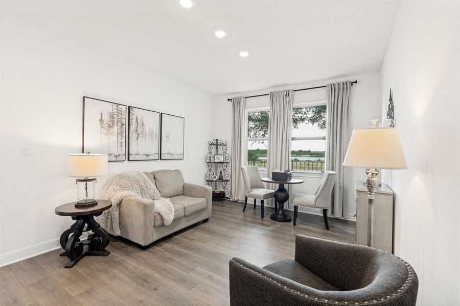 Recessed lighting illuminates wood-look flooring and multiple windows overlooking scenic water views.