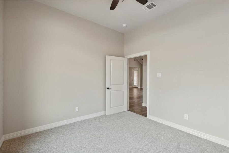 Carpeted spare room featuring ceiling fan