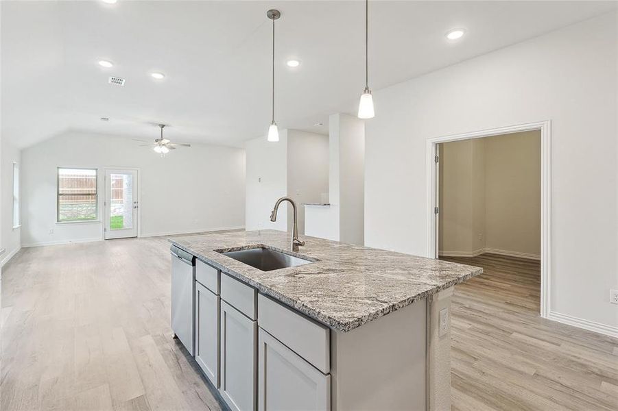 Kitchen featuring sink, light hardwood / wood-style floors, stainless steel dishwasher, an island with sink, and ceiling fan