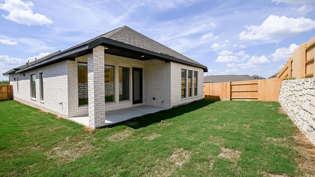 Rear view of property featuring brick siding, a fenced backyard, and a patio area Rear view of property featuring brick siding, a fenced backyard, and a patio area