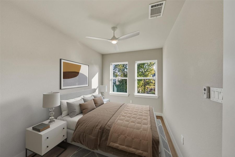 This virtually staged secondary bedroom offers a bright, inviting space with stylish decor and serene views, perfect for relaxation or hosting guests.