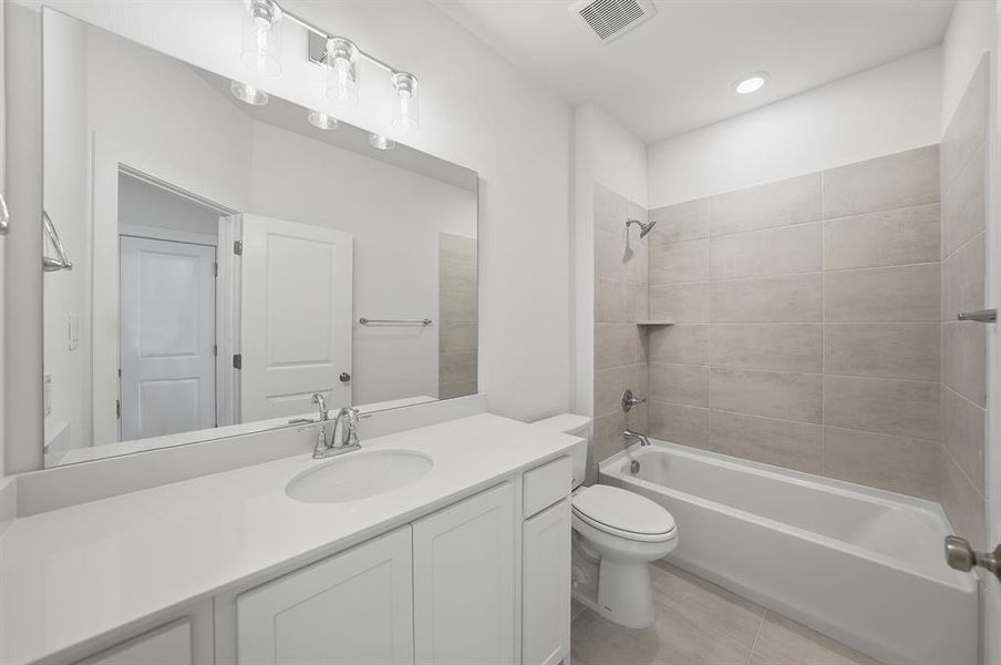 Full bathroom with shower combination, vanity, and light tile patterned floors Full bathroom with shower combination, vanity, and light tile patterned floors