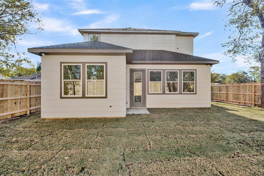 Rear view of property with roof with shingles and a fenced backyard