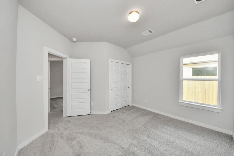 Generously sized secondary bedrooms featuring spacious closets, soft and inviting carpeting underfoot, large windows allowing plenty of natural light, and the added touch of privacy blinds for your personal retreat. Sample photo of completed home with similar floor plan. Actual colors and selections may vary.