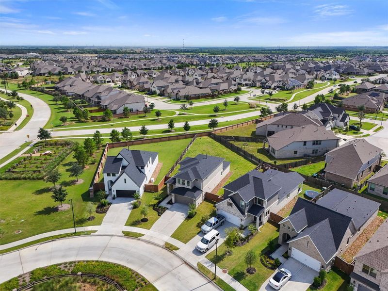 This wide aerial shot showcases the beauty of the Elyson community, with its meticulously planned streets and abundant green spaces. The home is positioned to offer easy access to all the fantastic community amenities and a quick commute out of the neighborhood.