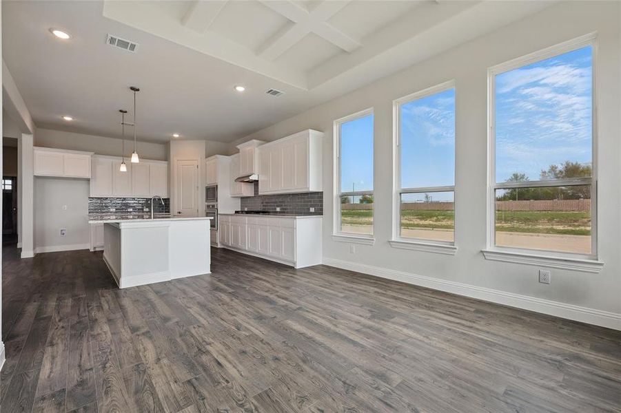 Kitchen featuring stainless steel microwave, dark wood-type flooring, baseboards, and visible vents