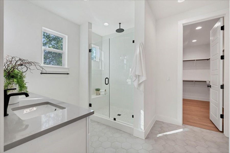 Primary bathroom features double vanity sinks, plenty of natural light, separate water closet, linen closet and standup shower