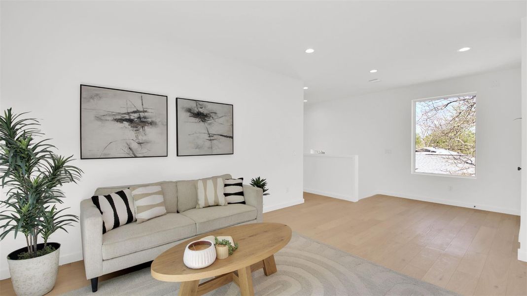 Living area with recessed lighting and light wood-style flooring