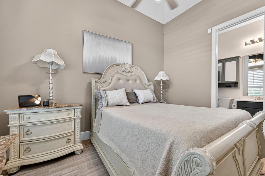 This cozy bedroom features an elegant bed with a tufted headboard, classic nightstands with ornate lamps, and neutral wall tones. The room is well-lit and adjoins a bathroom, creating a comfortable and convenient living space. This cozy bedroom features an elegant bed with a tufted headboard, classic nightstands with ornate lamps, and neutral wall tones. The room is well-lit and adjoins a bathroom, creating a comfortable and convenient living space.