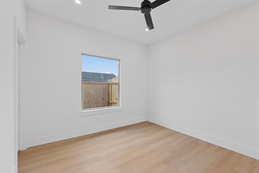 Spare room with light wood-type flooring, a ceiling fan, and recessed lighting