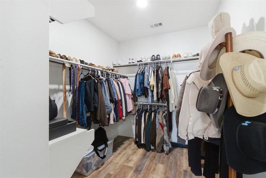 Walk in closet with light wood-style floors Walk in closet with light wood-style floors