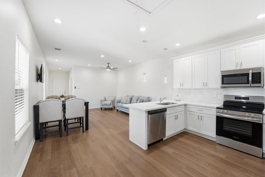 This open kitchen connects effortlessly to the living and dining areas, creating a bright, functional layout ideal for entertaining, hosting guests, or maximizing rental appeal.