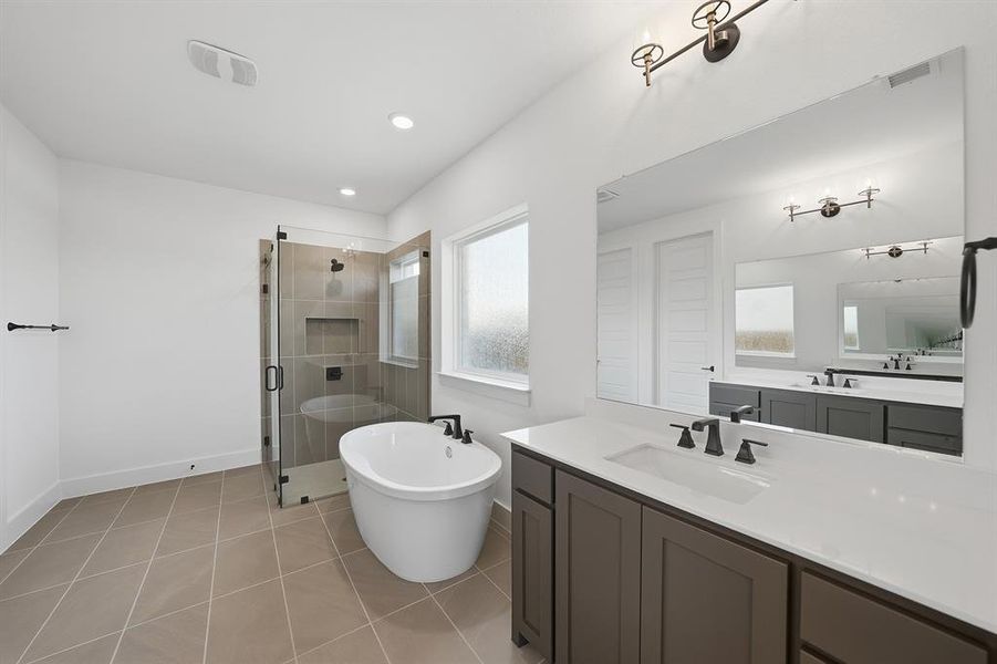 Full bathroom featuring vanity, a shower stall, a freestanding bath, light tile patterned floors, and recessed lighting Full bathroom featuring vanity, a shower stall, a freestanding bath, light tile patterned floors, and recessed lighting