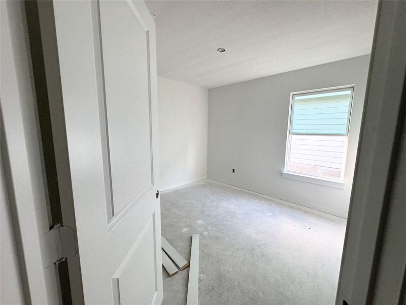Spare room with unfinished concrete flooring