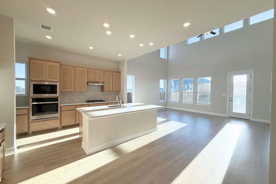 Kitchen featuring an island with sink, recessed lighting, stainless steel appliances, light wood-style floors, and open floor plan