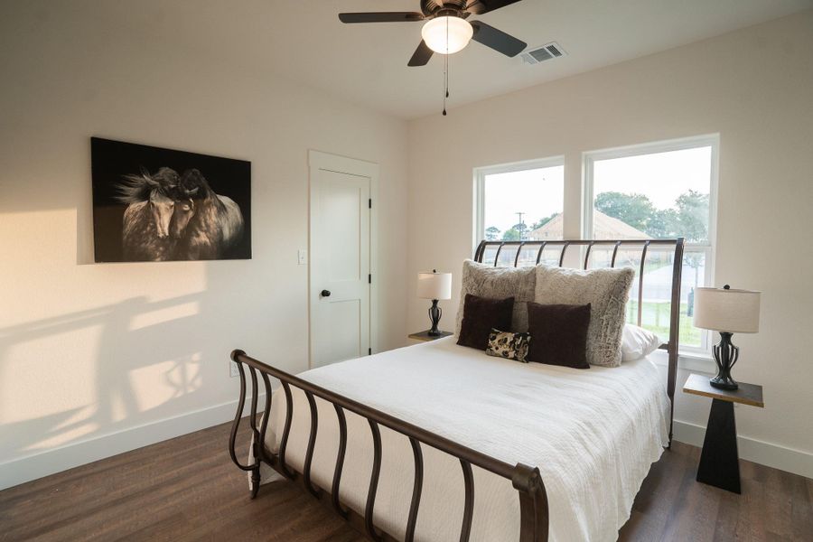 Bedroom with baseboards, dark wood-style floors, and a ceiling fan