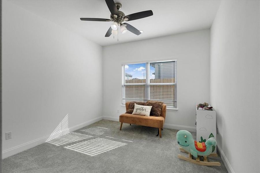 Living area featuring carpet and ceiling fan Living area featuring carpet and ceiling fan