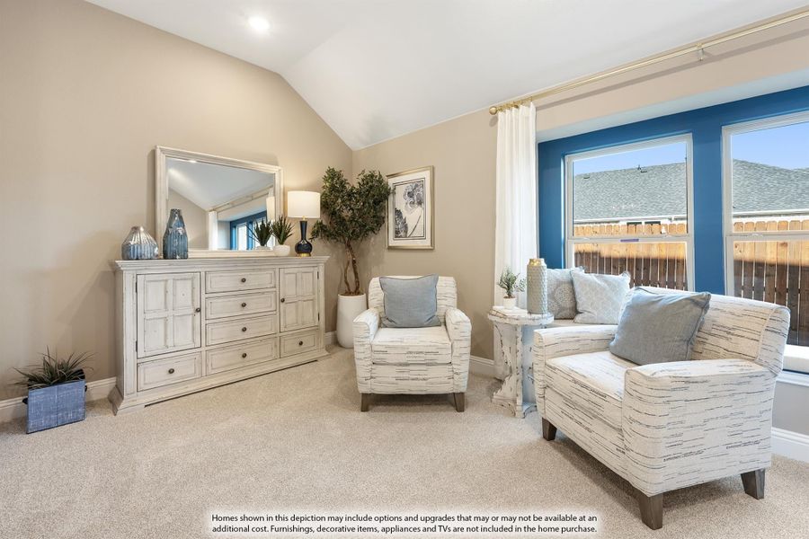Bedroom sitting area with vaulted ceiling, two accent chairs, white dresser, and large windows with blue accent wall. Bedroom sitting area with vaulted ceiling, two accent chairs, white dresser, and large windows with blue accent wall.