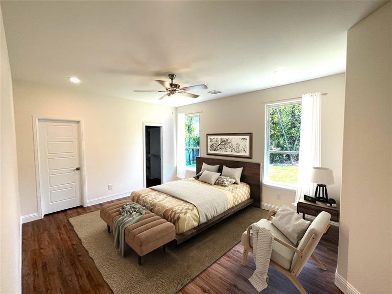 Bedroom featuring ceiling fan, dark hardwood / wood-style flooring, and a walk in closet