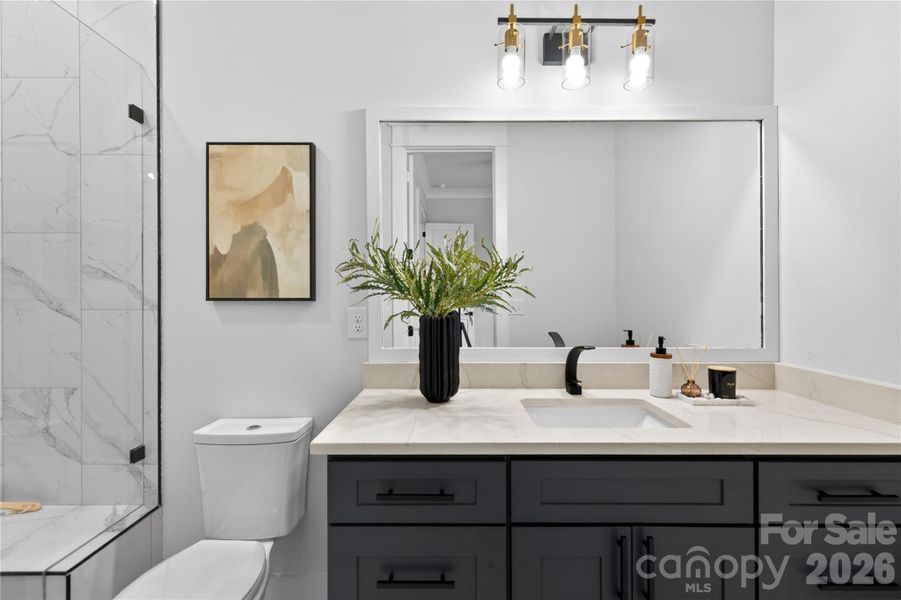 Even the guest bathrooms feel thoughtfully designed with warm finishes, custom cabinetry, and details that don’t feel builder basic