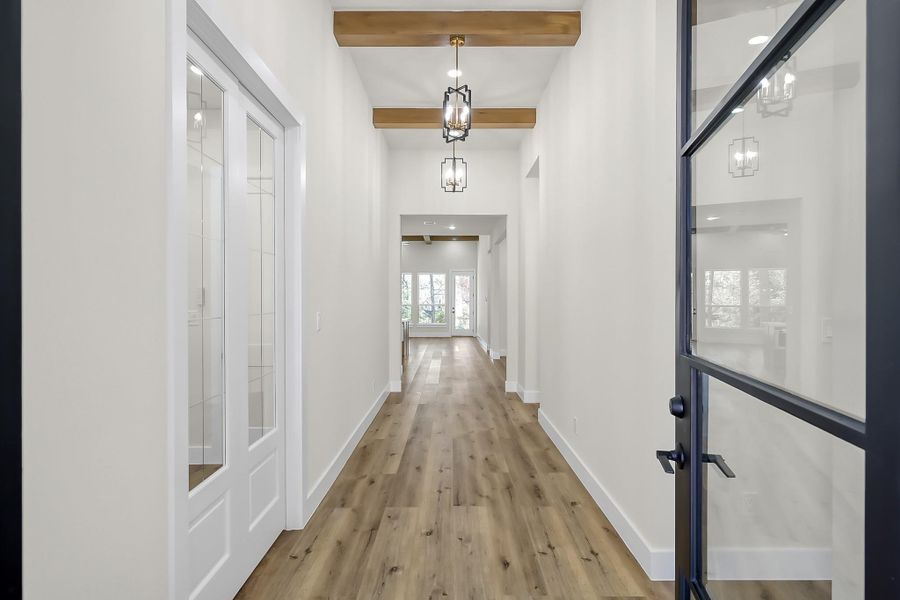 Wood look LVP, wood beams and an abundance of natural light welcome you into your brand new construction home.