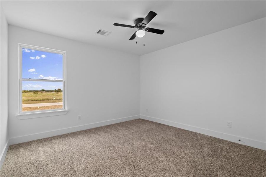 Empty room with light colored carpet and ceiling fan Empty room with light colored carpet and ceiling fan