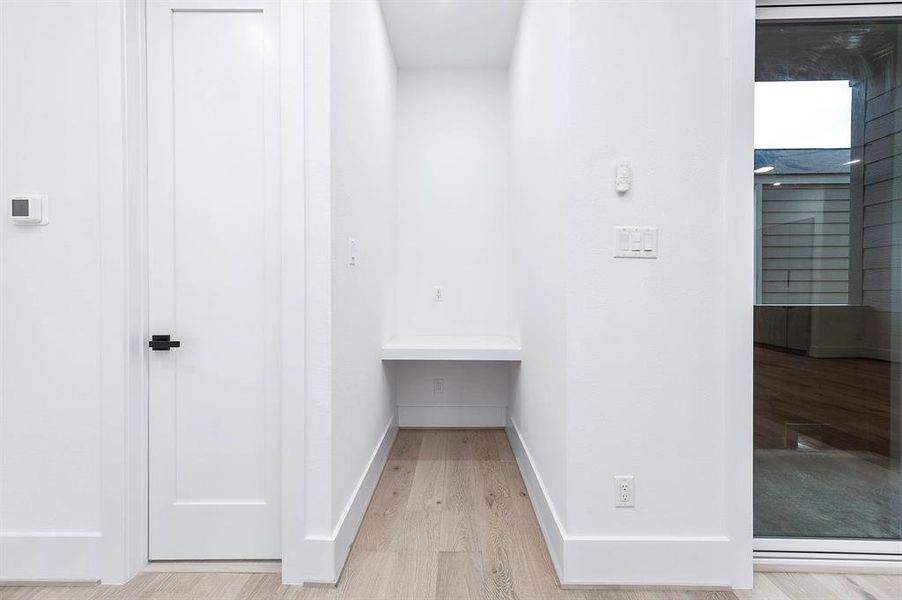 This photo shows a modern, compact space with a built-in desk area, ideal for a small home office or study nook. It features clean lines, a sliding glass door for natural light, and minimalist design, offering a tranquil spot for work or reading.