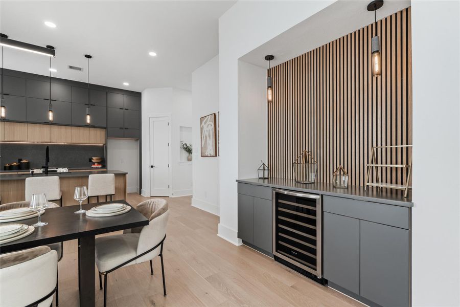 Designed with the entertainer in mind, this built-in dry bar offers a moment of visual drama and functional luxury. Vertical oak slats add architectural rhythm, while graphite cabinetry and a wine fridge elevate the everyday ritual of pouring and pairing. It’s the kind of detail that turns a house into a host’s dream. Designed with the entertainer in mind, this built-in dry bar offers a moment of visual drama and functional luxury. Vertical oak slats add architectural rhythm, while graphite cabinetry and a wine fridge elevate the everyday ritual of pouring and pairing. It’s the kind of detail that turns a house into a host’s dream.