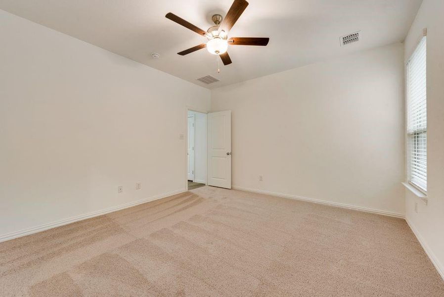 Carpeted empty room with ceiling fan