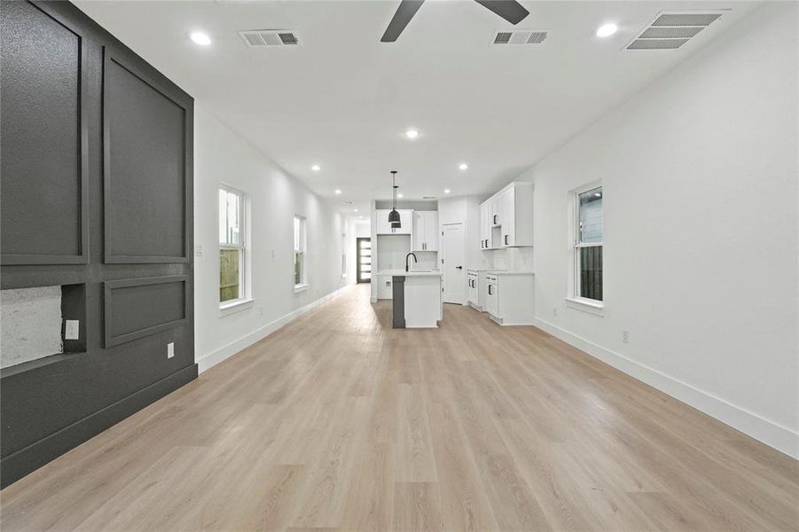 Unfurnished living room with recessed lighting, light wood finished floors, and a ceiling fan Unfurnished living room with recessed lighting, light wood finished floors, and a ceiling fan