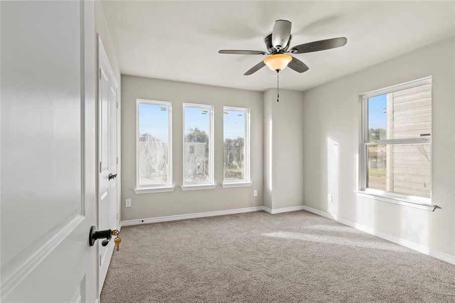 Unfurnished room with light colored carpet and ceiling fan