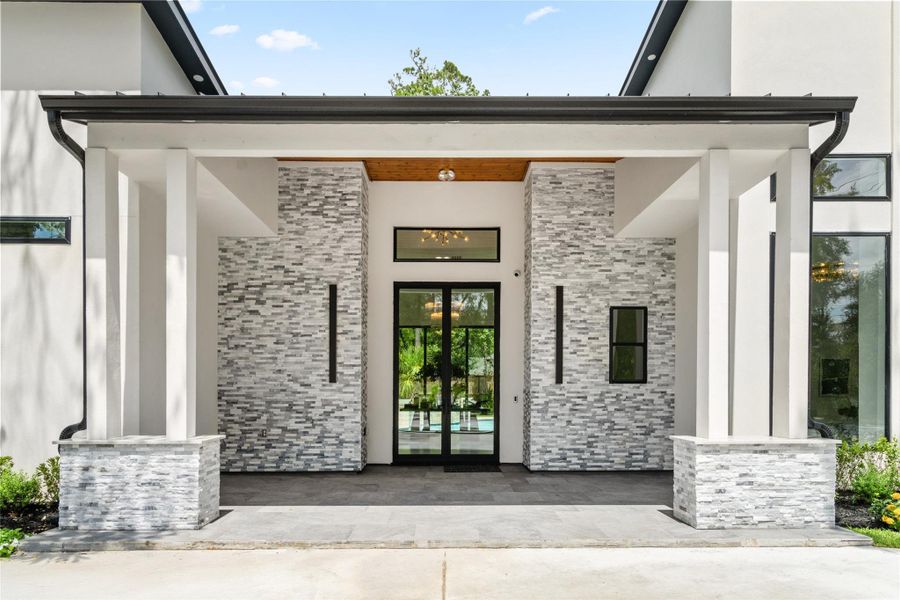 A gracious covered entry sets the stage with a stained pine ceiling, modern columns, and contemporary lighting—offering a stylish first impression that hints at the thoughtful design within. A gracious covered entry sets the stage with a stained pine ceiling, modern columns, and contemporary lighting—offering a stylish first impression that hints at the thoughtful design within.