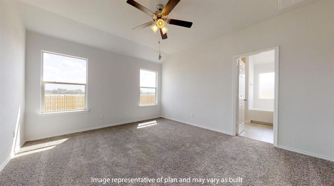 Spacious room featuring neutral carpeting, a ceiling fan with integrated lighting, two windows with white trim, and a doorway leading to a tiled bathroom with a tub Spacious room featuring neutral carpeting, a ceiling fan with integrated lighting, two windows with white trim, and a doorway leading to a tiled bathroom with a tub