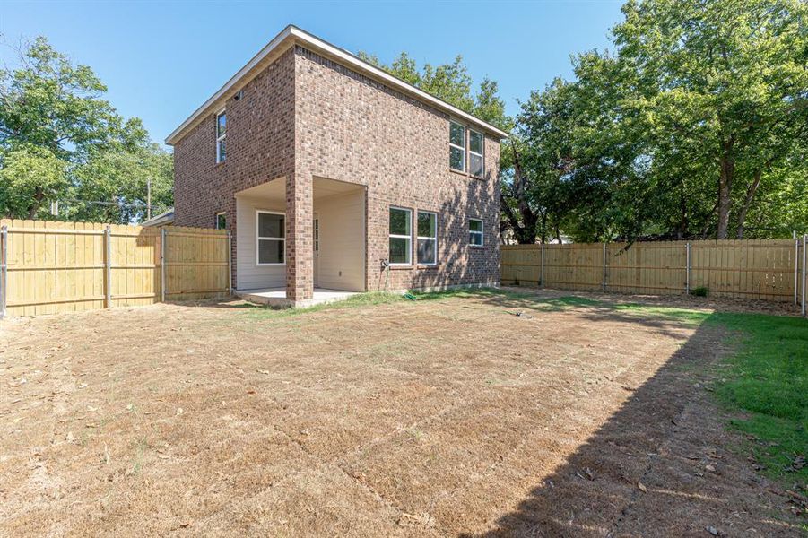 Back of property with a patio area, brick siding, and a fenced backyard