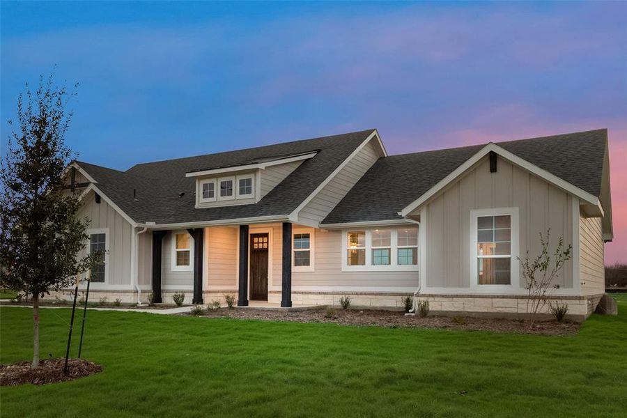 View of front of property featuring a shingled roof, board and batten siding, and a front yard