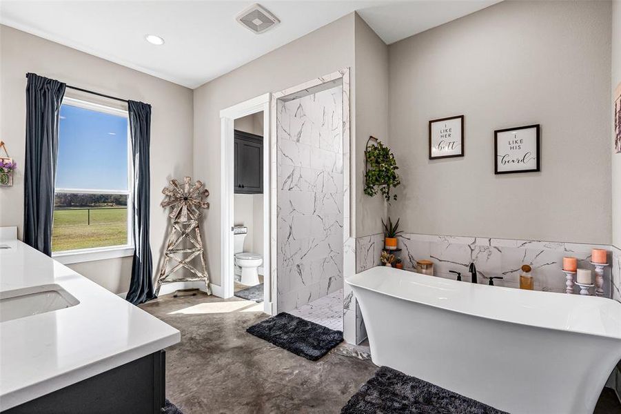 Full bathroom featuring double vanity, a soaking tub, a walk in shower, and concrete floors Full bathroom featuring double vanity, a soaking tub, a walk in shower, and concrete floors