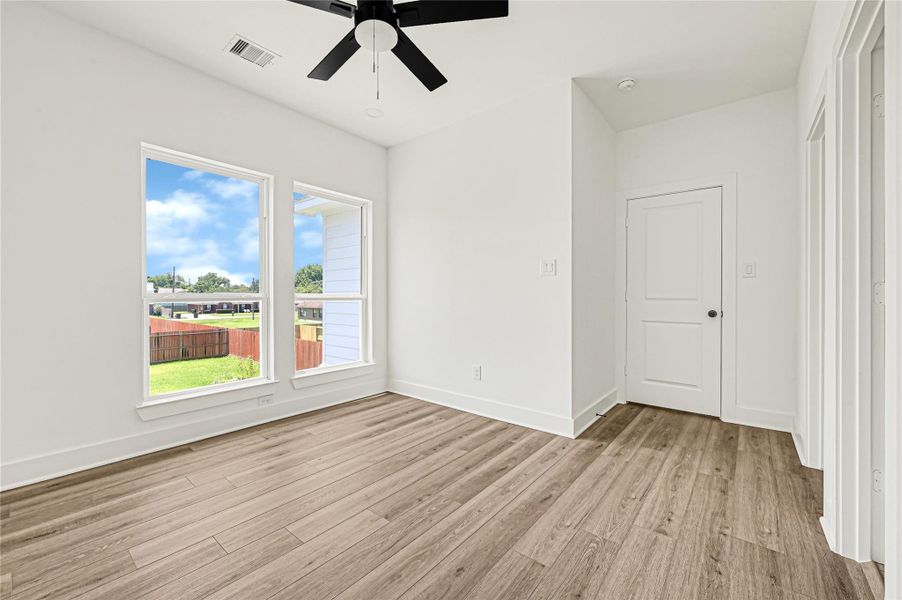 Spacious bedroom with natural light and ceiling fan. Spacious bedroom with natural light and ceiling fan.